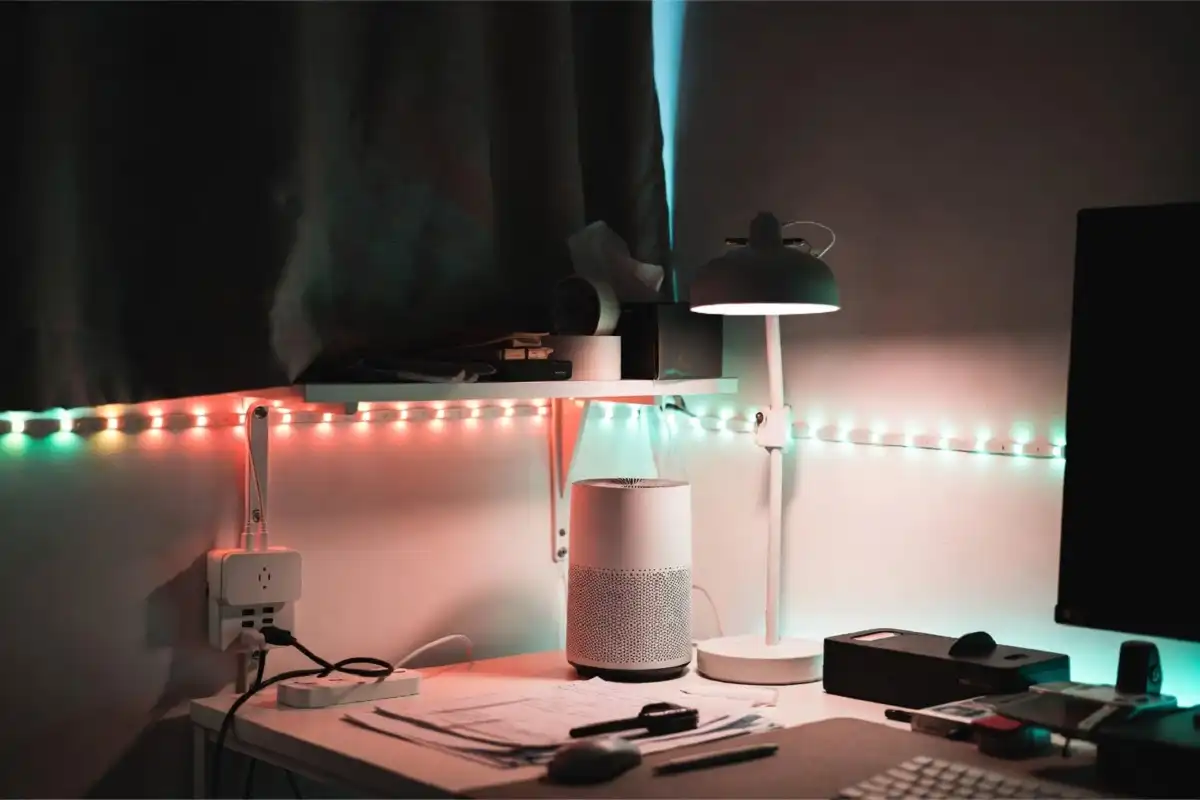 Affordable home gadgets including a smart plug, LED strip lights, and a mini air purifier on a home office desk