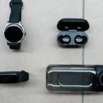 Flat lay of the best fitness gadgets including a smartwatch, fitness band, and wireless earbuds