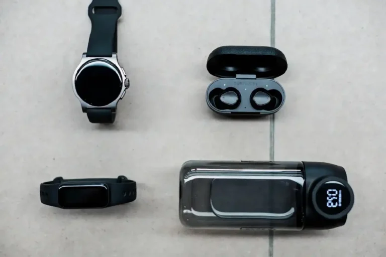 Flat lay of the best fitness gadgets including a smartwatch, fitness band, and wireless earbuds
