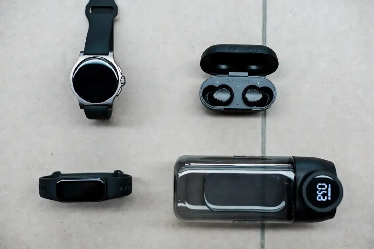 Flat lay of the best fitness gadgets including a smartwatch, fitness band, and wireless earbuds