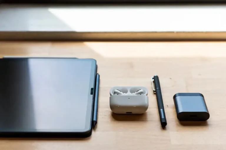Best school gadgets arranged on a student desk including tablet, stylus, earbuds, and smart pen