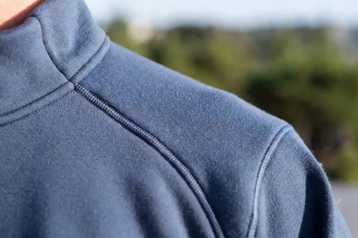 Close-up of Nike Tech fleece fabric in blue showing the soft bonded material and zipper detail