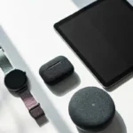 A curated flat lay of dream gadgets including a smartwatch, tablet, and wireless earbuds on a white desk