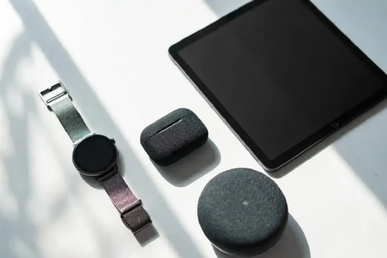 A curated flat lay of dream gadgets including a smartwatch, tablet, and wireless earbuds on a white desk