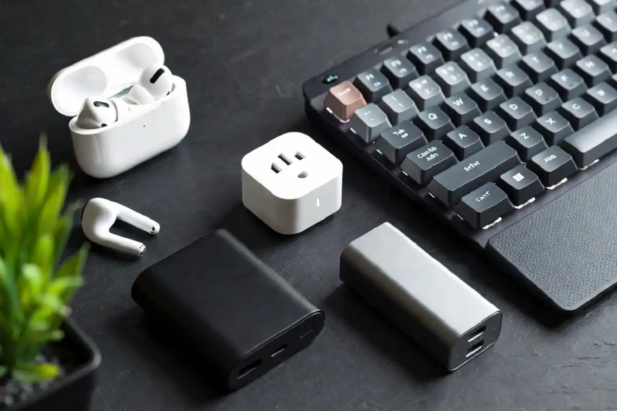 Flat lay of best electronics gadgets including earbuds, power bank, and smart plug