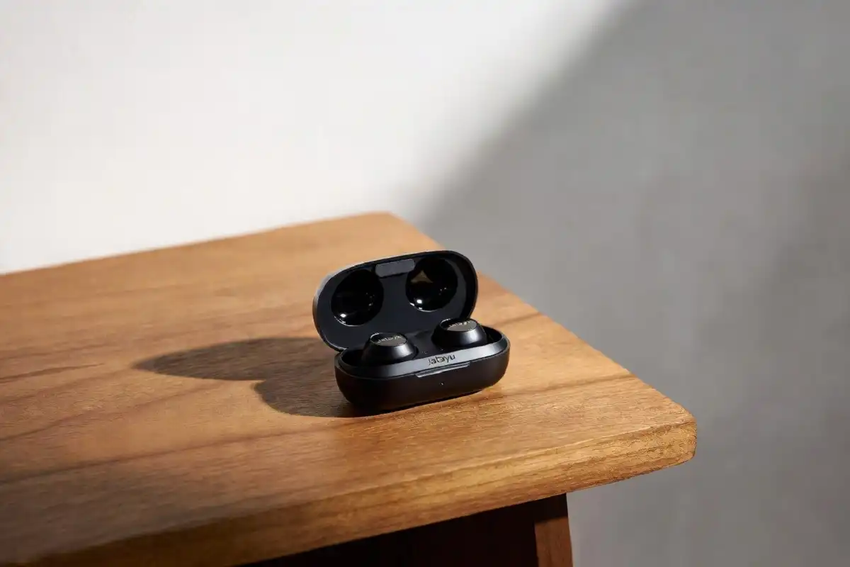 Jatayu wireless earbuds in charging case on wooden surface