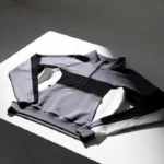 Nocta tech fleece hoodie laid flat on a white surface in editorial product photography style