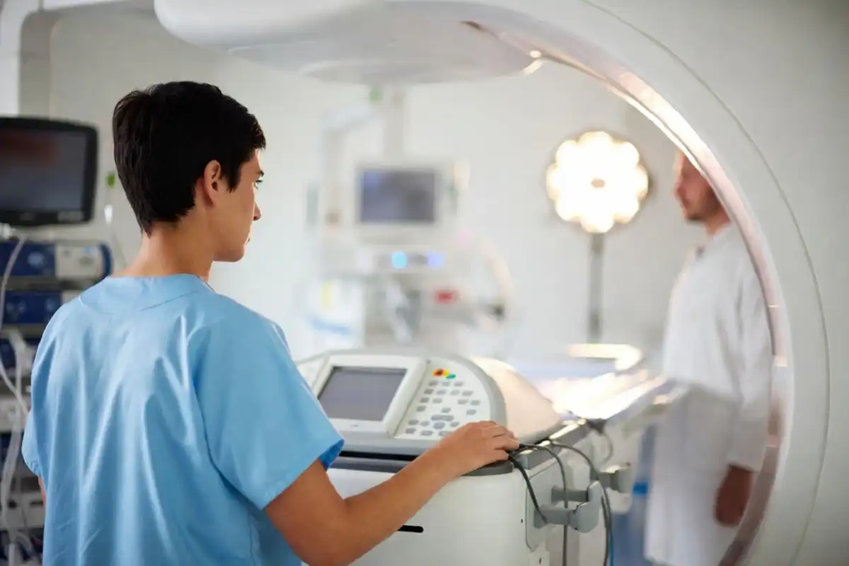 A radiology technology student practicing on imaging equipment during a clinical training session
