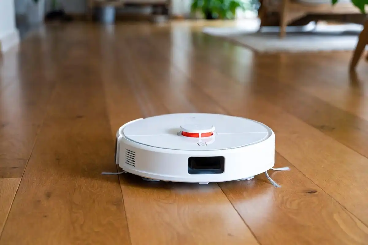 Robot vacuum cleaning hardwood floor in modern home