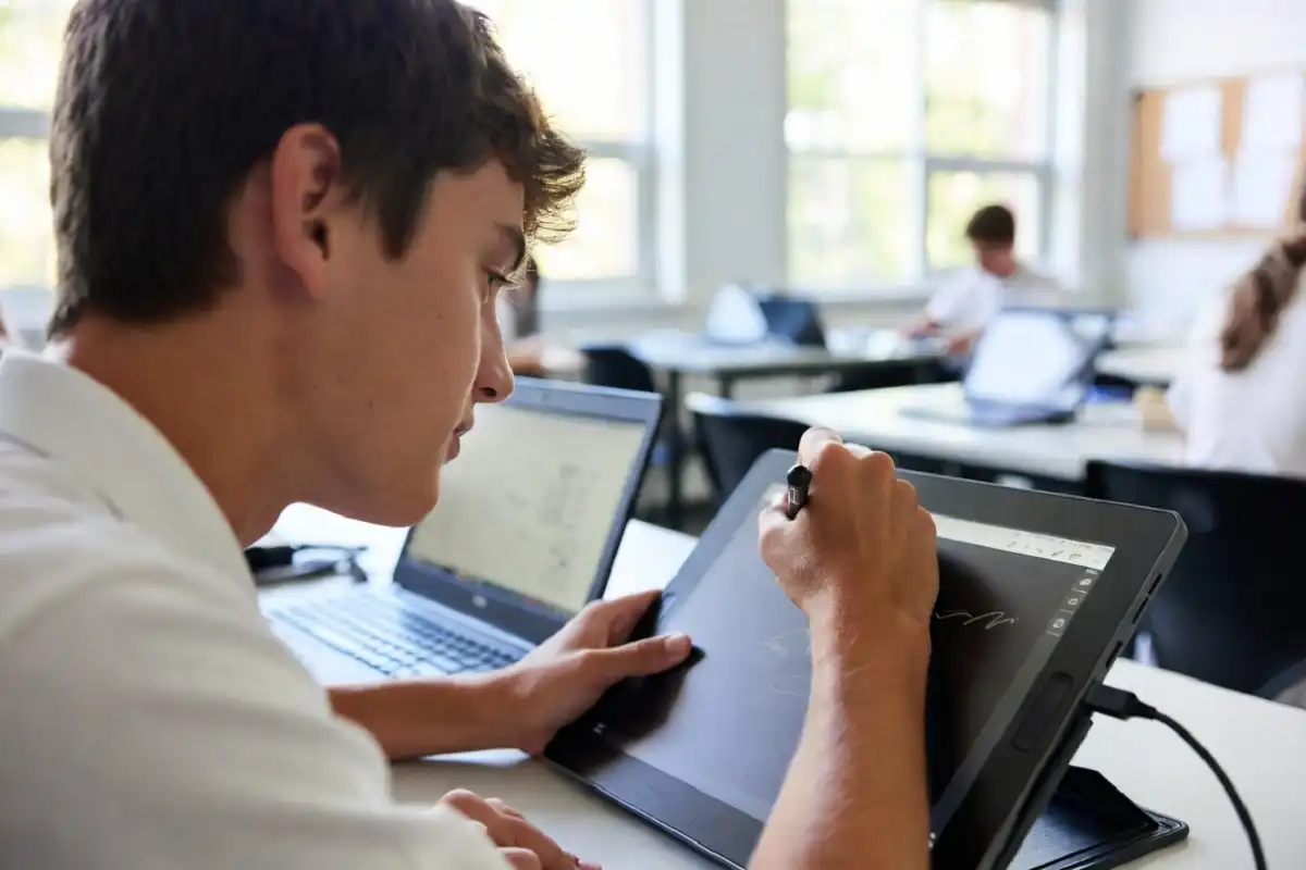 Student using a digital tablet as a school gadget for note-taking in a modern classroom