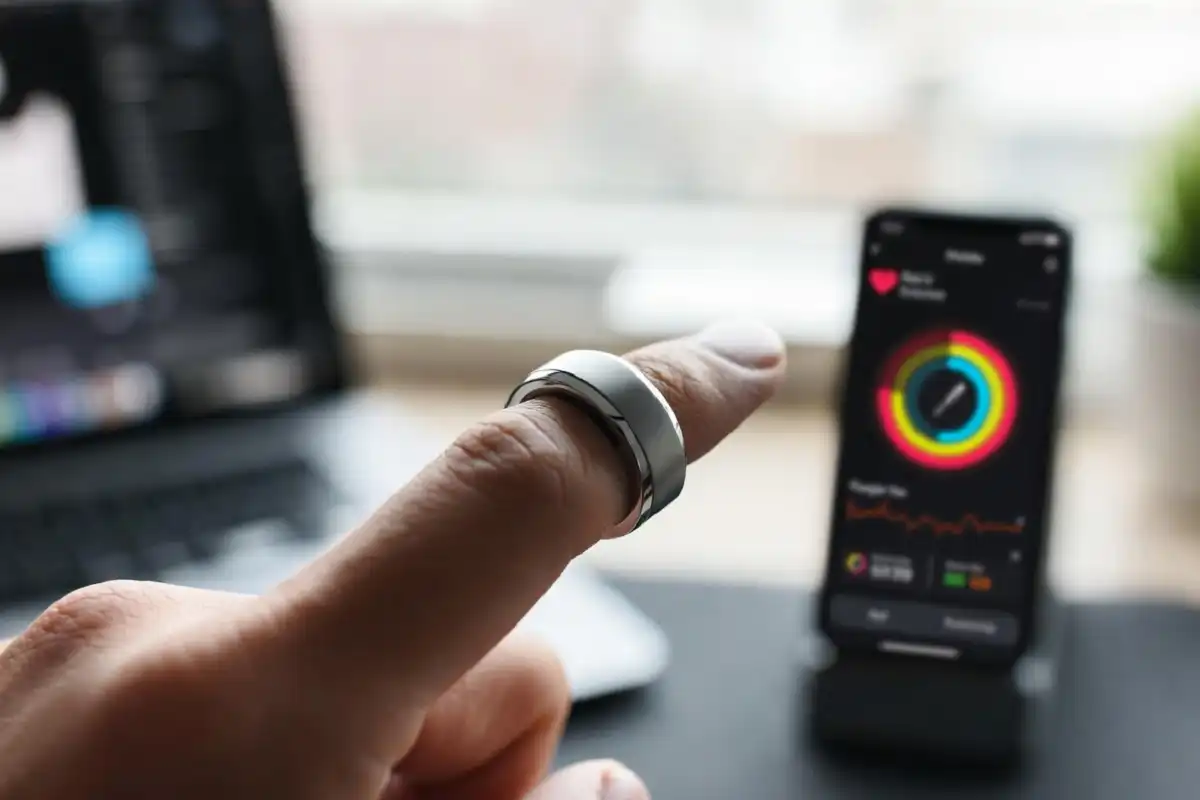 Smart ring on a man's hand showing fitness tracking features