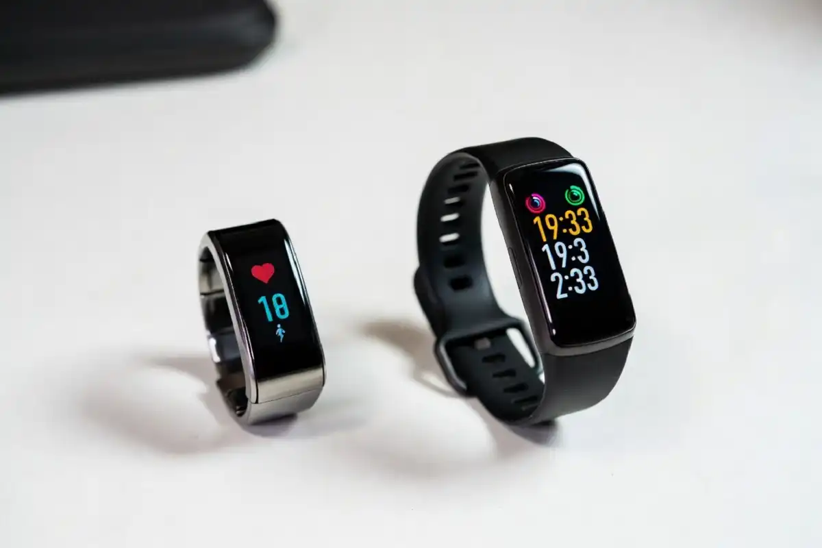 Smart ring and fitness tracker side by side showing health and fitness data