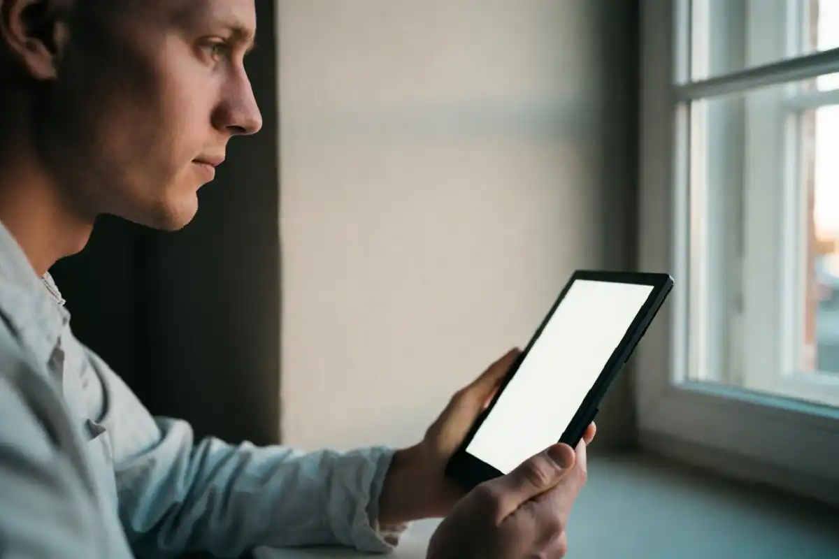 Person reading on a minimalist e-ink reader in a quiet room