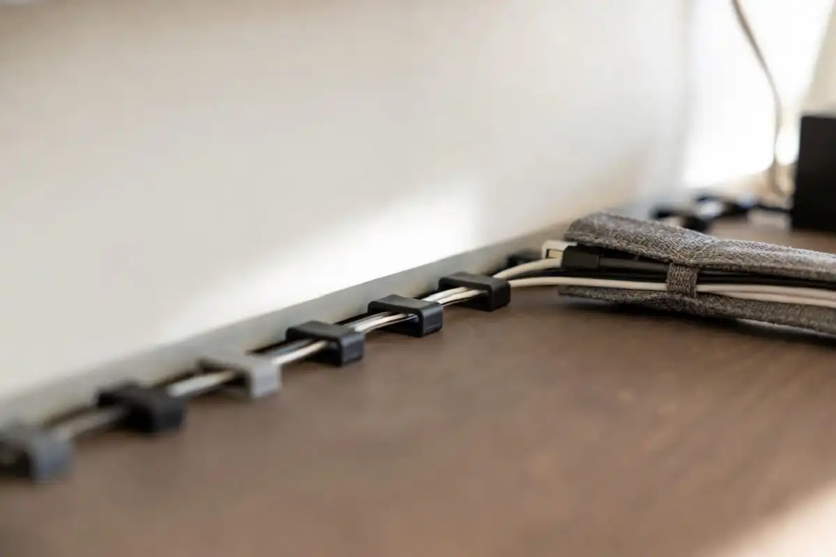 Cable management clips organizing wires under a minimalist desk