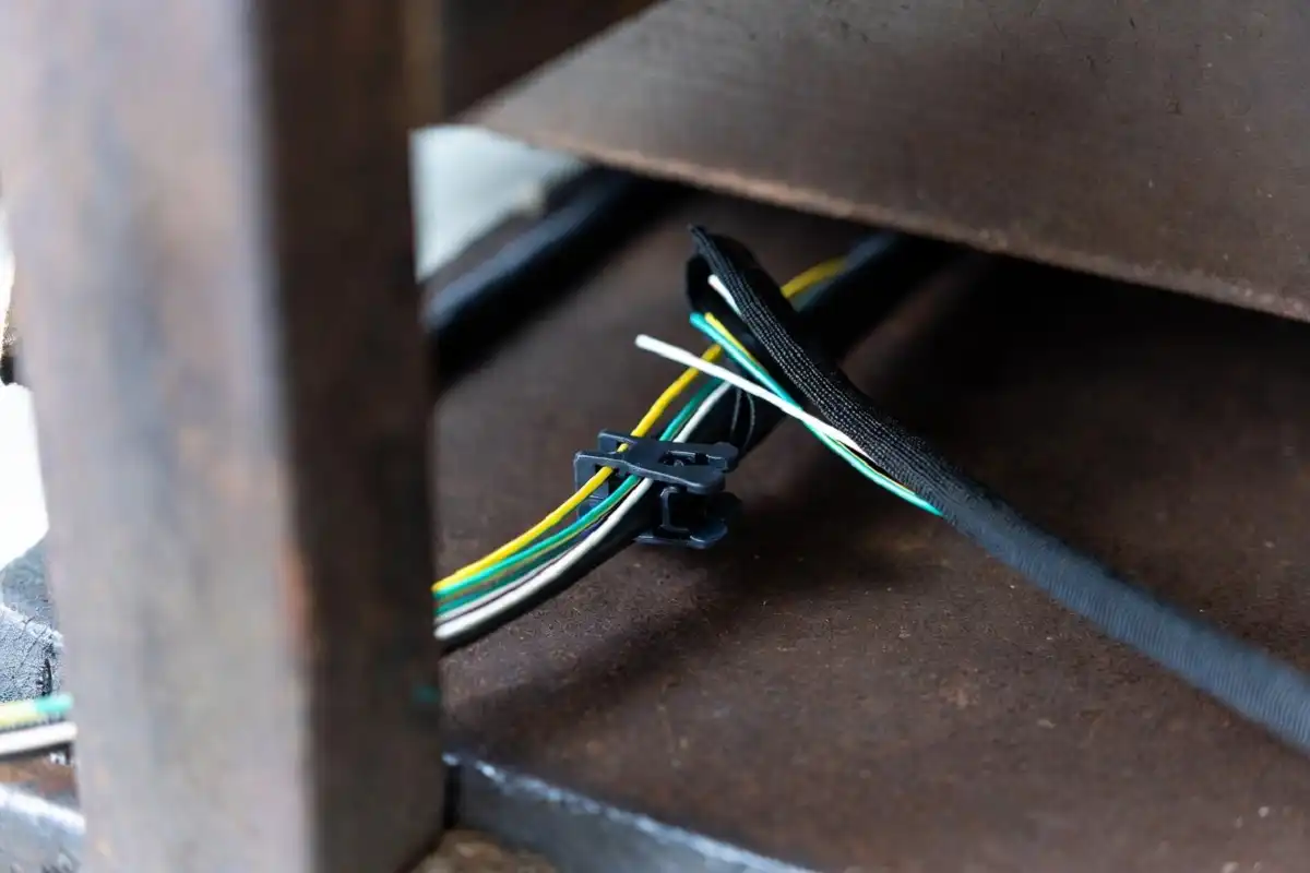 Cable clips and sleeve organizing wires under a men's office desk